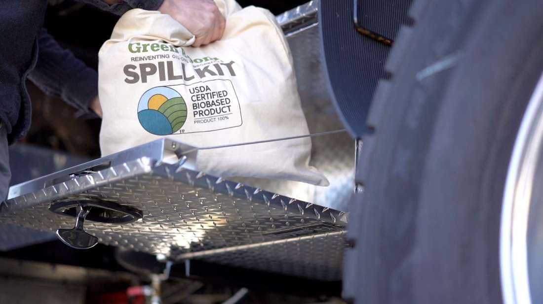 Green Boom spill kit stored on a truck step